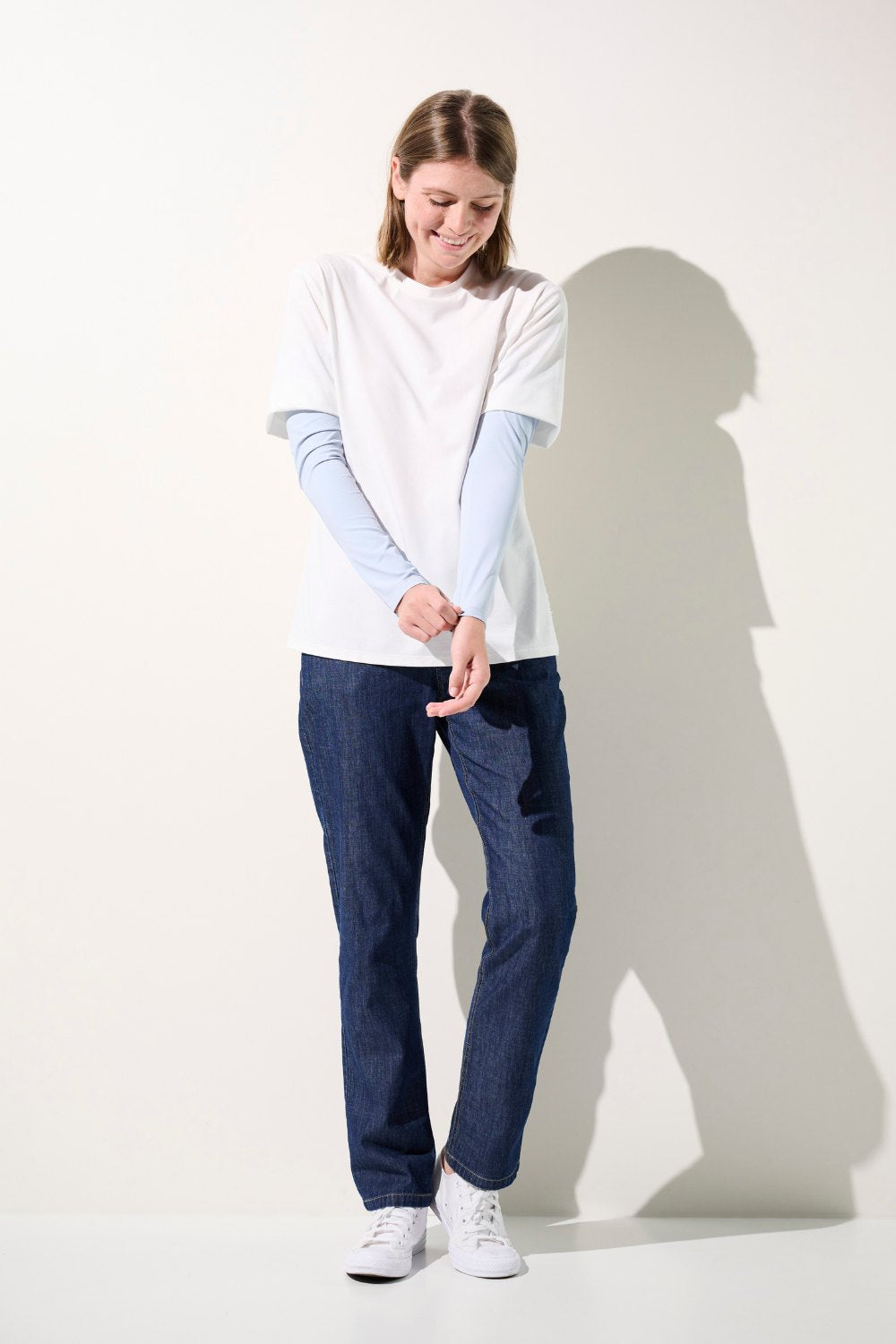 Femme portant un t-shirt blanc et des manches anti-UV Gobi bleues, confortables et élégantes, protectrices UPF 50+.