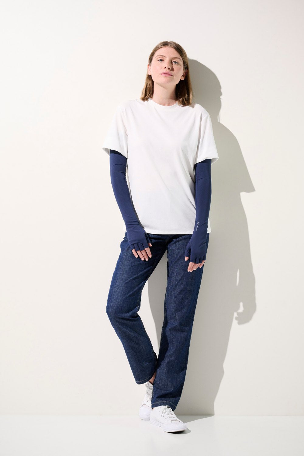 Femme portant des mitaines à manches anti-UV Mojave bleues et t-shirt blanc, protection solaire UPF 50+.