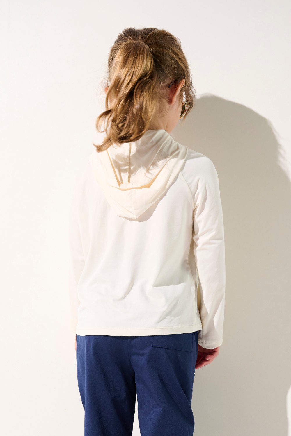 T-shirt anti-UV à capuche blanc UPF 50+ pour enfant, léger et confortable, parfait pour jouer au soleil.