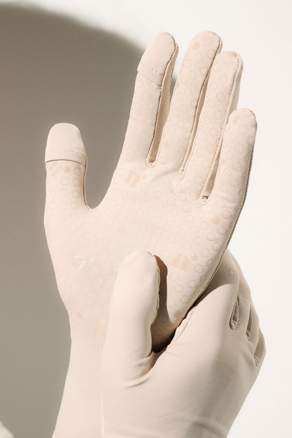 Gants anti-UV beige UPF50+, offrant confort et adhérence pour activités en extérieur.