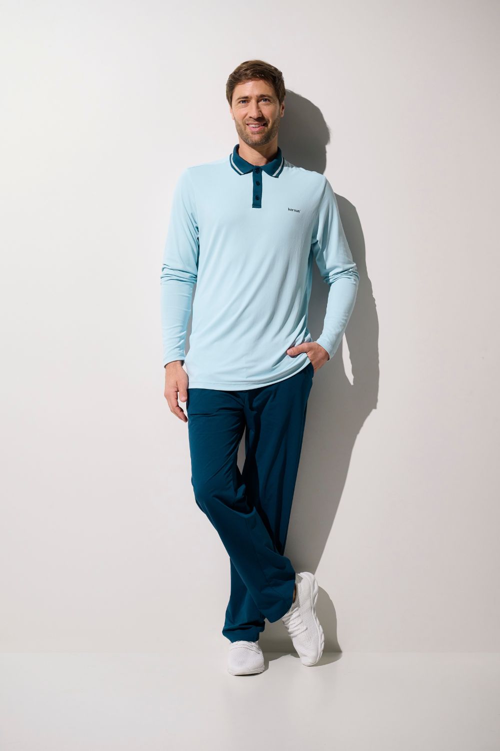 Homme portant un polo anti-UV Augusta léger et respirant, couleur bleu clair, avec protection UPF 50+.
