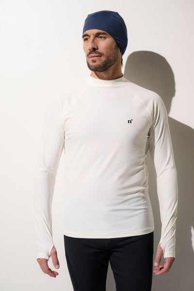 Homme portant un t-shirt de bain anti-UV crème, manches longues, UPF 50+, idéal pour activités aquatiques.