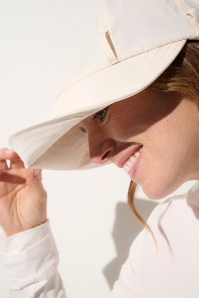 Casquette anti-UV beige pour femme, légère et pliable, offrant une protection solaire UPF50+ lors d'activités de plein air.