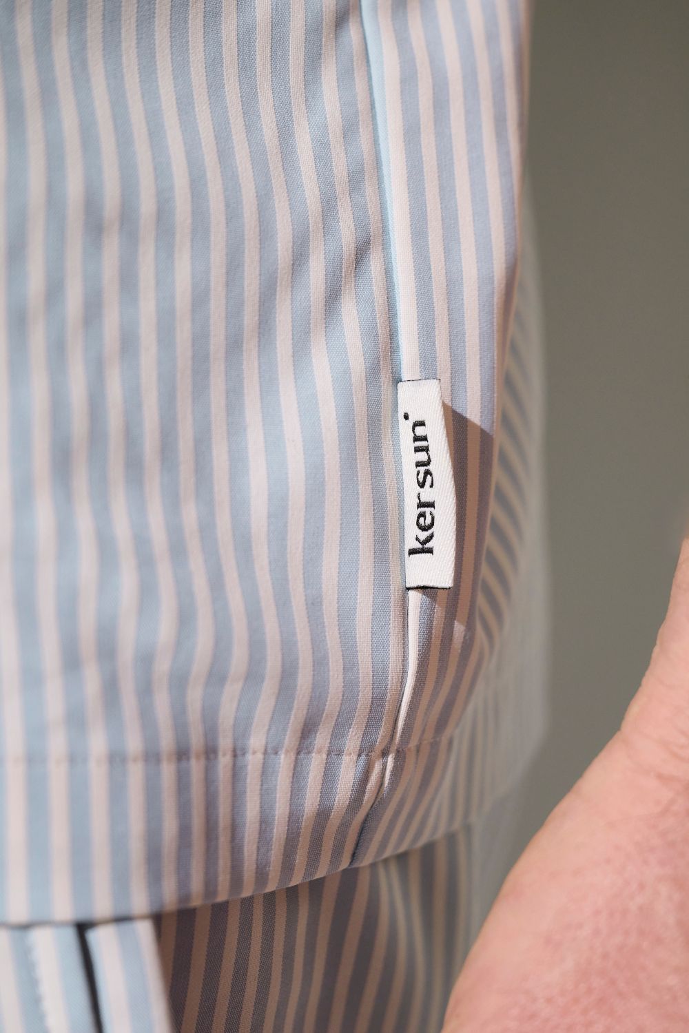 Détail de la chemise anti-UV bleue rayée de Ker Sun, étiquette visible avec logo sur le côté.