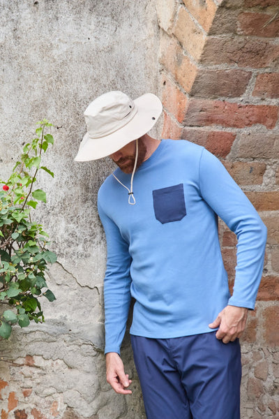 Homme portant un chapeau anti-UV - Sequoia et un t-shirt léger, couleur bleu, adapté pour la randonnée en plein air.