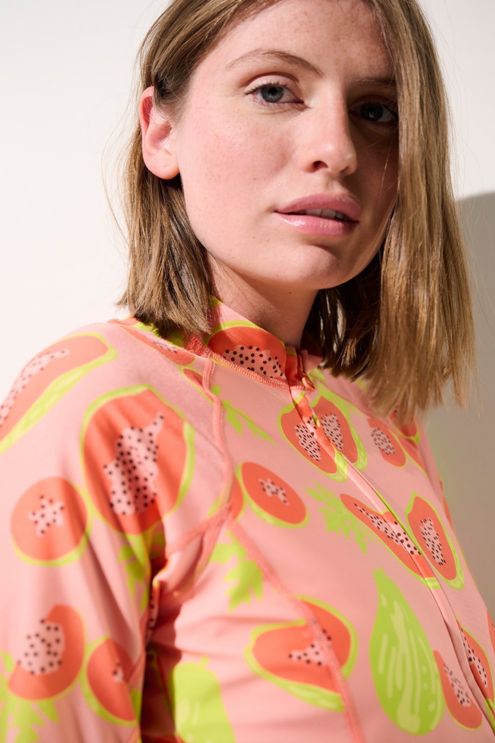 Femme se protégeant du soleil avec une veste de bain anti-UV certifiée UPF 50+.