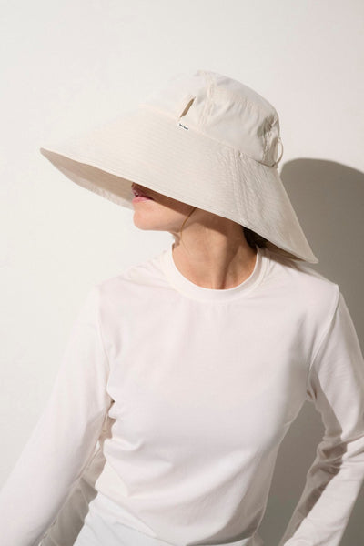 Chapeau anti-UV blanc pour femme, offrant une protection solaire élégante et confortable.