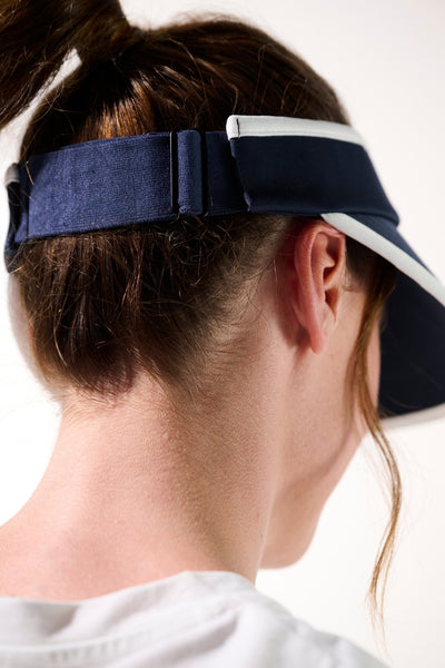 Visière anti-UV - Augusta, bleue, portée par une femme, parfaite pour le sport et la protection solaire UPF 50+.