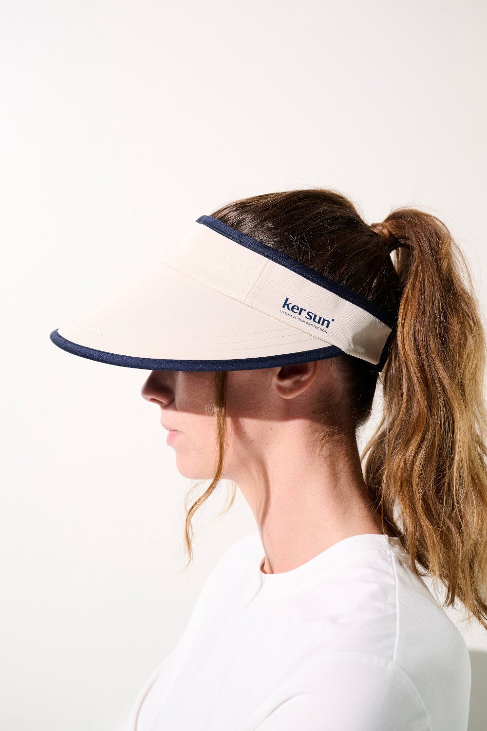 Visière anti-UV - Augusta beige avec logo Ker Sun, protection solaire UPF 50+, portée par une femme active.